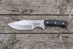 Hand forged tracker knife with black micarta handle shown in full side profile on grey weathered boards