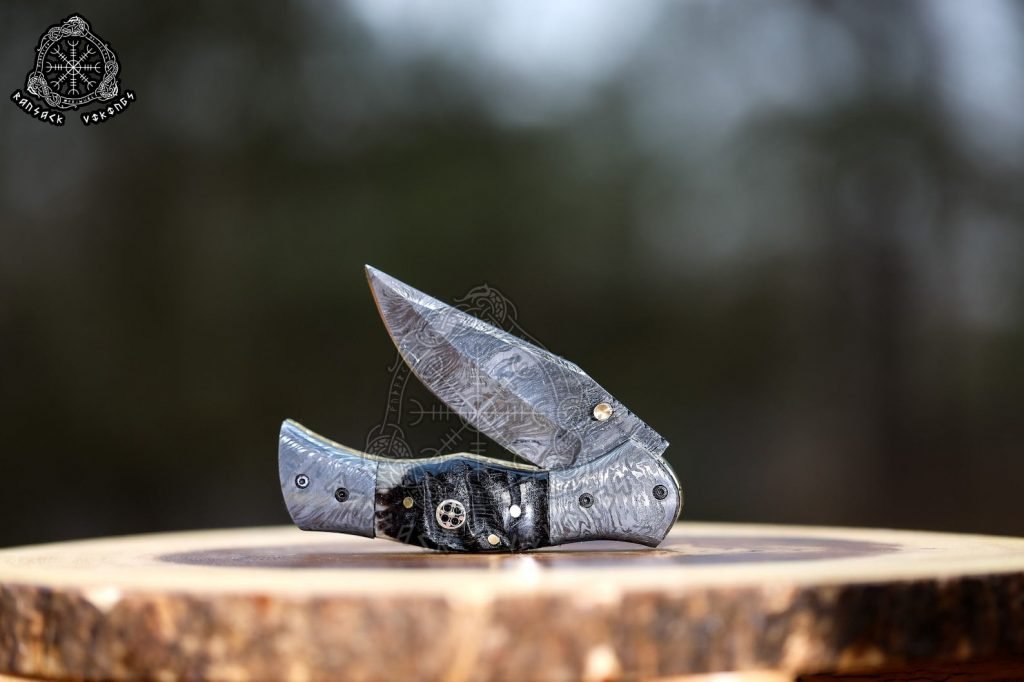 Damascus Folding Pocket Knife — Hand-Forged, 7.5″ Overall, Ram Horn Handle, Leather Sheath