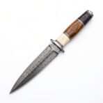 Damascus steel double edged dagger with layered bone and wood handle shown diagonally on a plain white background