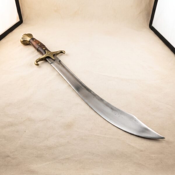 Hand forged scimitar with a satin finished 1095 steel blade, brass quillons and riveted hardwood grip, photographed on a pale sand coloured canvas backdrop