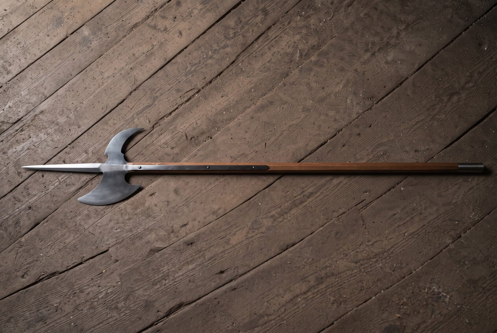 Gemini_Generated_Image_tkrgw1tkrgw1tkrg Battle halberd with a satin steel spike, crescent blade and hooked fluke on a long hardwood haft laid across a dark weathered plank floor