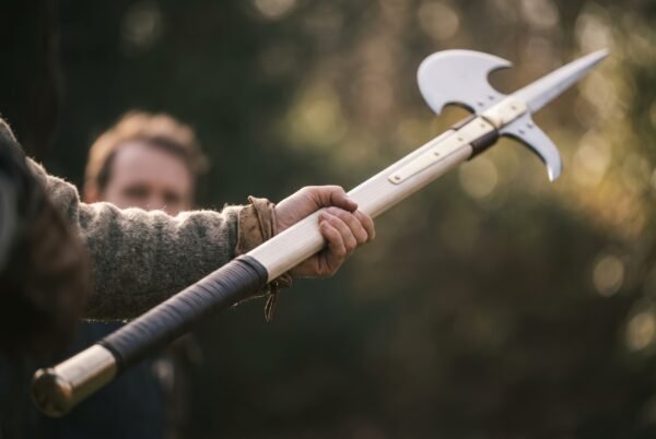Halberd with steel spike and crescent blade on a pale ash haft with leather wrapped grip held out at arm length