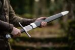 Steel arming sword with etched Mjolnir panel and straight cross being drawn from its black scabbard