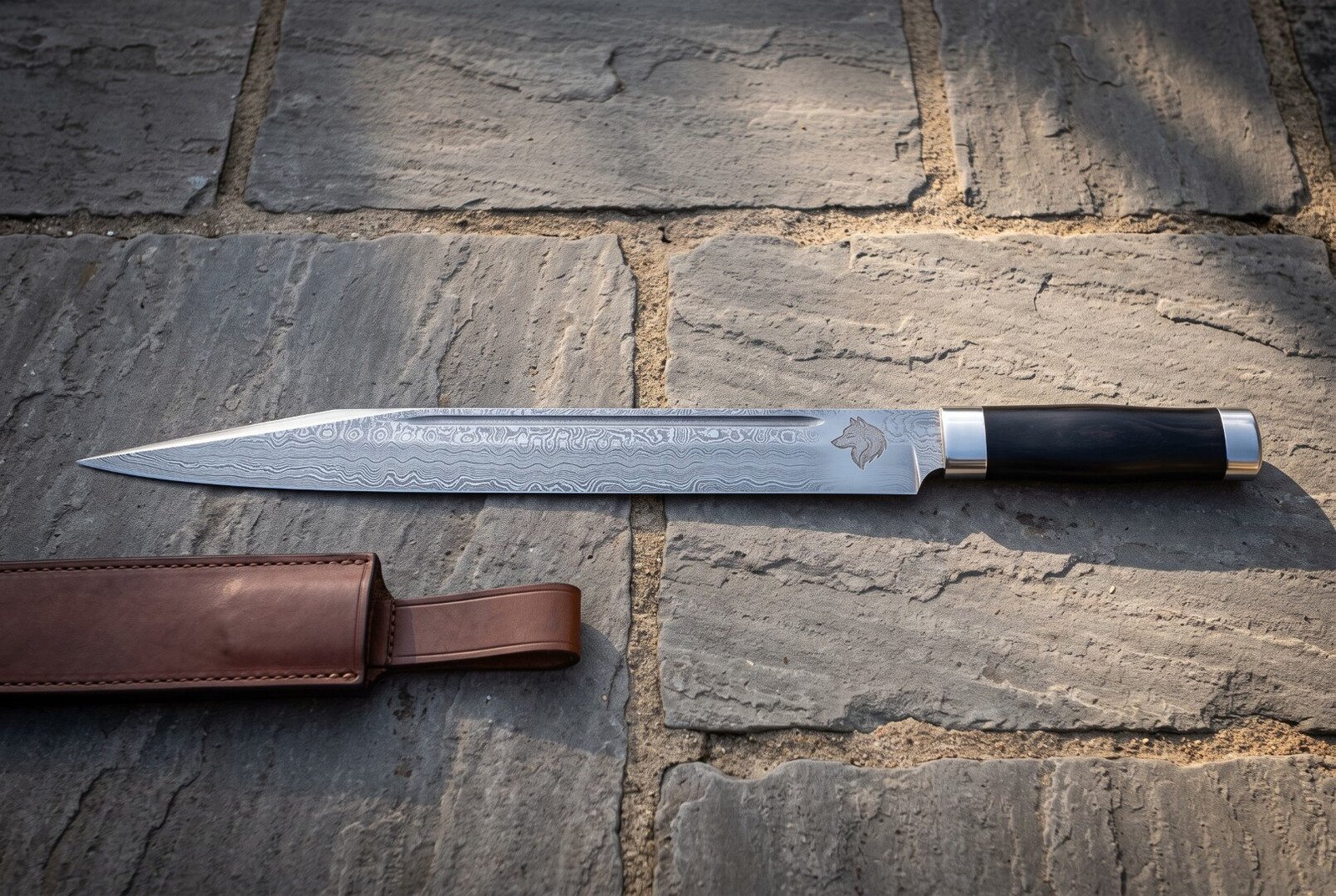 Gemini_Generated_Image_e5pqape5pqape5pq Hand forged Damascus seax knife with a wolf head etch and dark buffalo horn handle lying on stone flagstones beside a brown leather belt sheath in warm light
