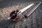 Black leather grip banded twice in silver wire, a faceted ball pommel closing the hilt