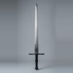 Blackened longsword trainer with twin low fullers, faceted barrel pommel and black cord wrapped grip standing point up against a plain grey studio backdrop