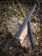 Blackened steel sword with octagonal tree pommel and curved cross leaning on a tree stump beside its black scabbard