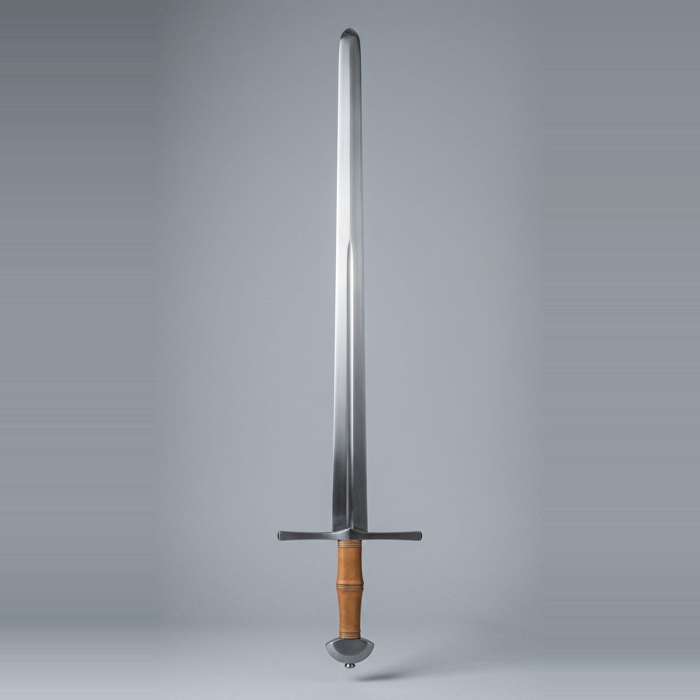 Faskvar blunt arming sword Blunt arming sword trainer with a narrow fullered blade, plain straight cross and demi lune pommel over a tan leather grip with three cord risers against a plain grey studio backdrop