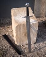Bossed steel wheel pommel on a Damascus arming sword with a fitted black leather scabbard