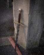 Brass guard closing into ring terminals with a downturned finger loop below the flame blade