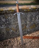Broad steel crossguard and a faceted scent stopper pommel over a tan leather grip