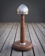 Brushed steel four panel spangenhelm cap with a brow band displayed on a turned walnut stand with a round base