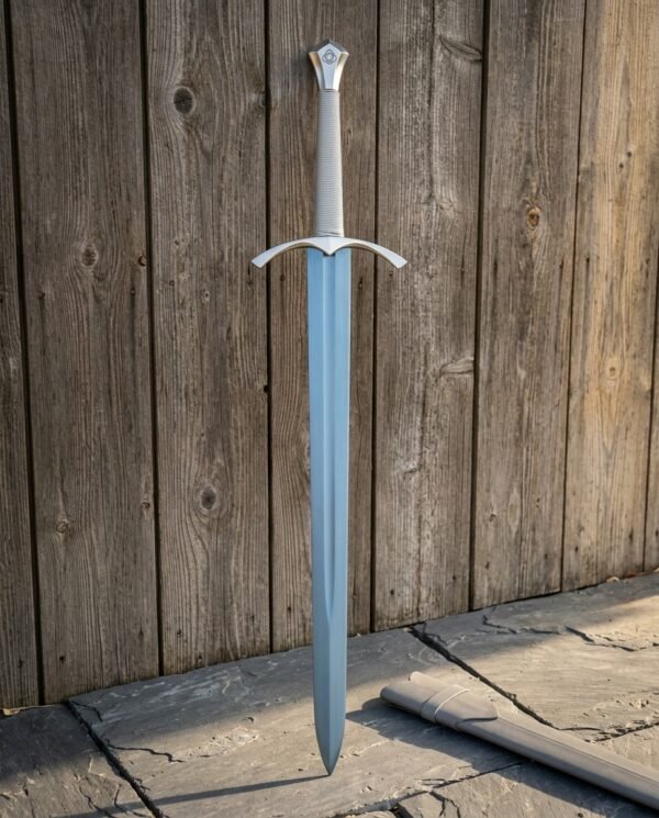 Cord wrapped longsword in satin polished 1095 steel with an arched guard and engraved shield pommel standing upright against a weathered grey plank fence