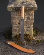 Damascus hooked sabre with pale wood grip and brass triskele ferrule hanging on a stone pillar above its tan scabbard