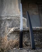 Damascus ninjato with straight blade, triple spiral collar and black cord wrapped handle standing beside its black scabbard