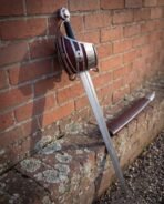 Damascus short sword with its brown leather scabbard, red shell panels and peened full tang