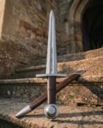 Damascus steel sword standing point up on stone steps with the wheel pommel down, crossed with its dark timber scabbard