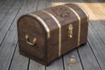 Dark stained wooden Viking chest with domed lid, brass straps and Helm of Awe engraving on a wooden deck