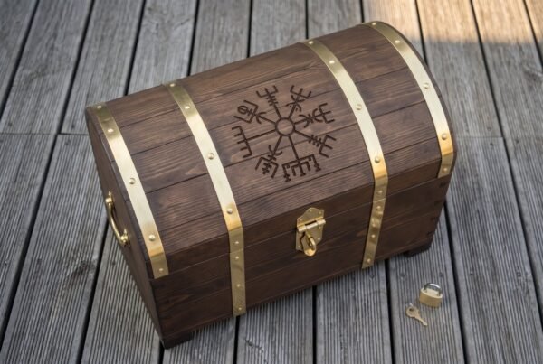 Domed wooden storage chest with studded brass bands and engraved lid next to a small brass padlock and key