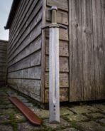 Elder Futhark inscription cut along the arched guard, olive green leather grip between brass ferrules