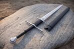 Etched valknut sitting just above the ricasso on a bright polished longsword blade