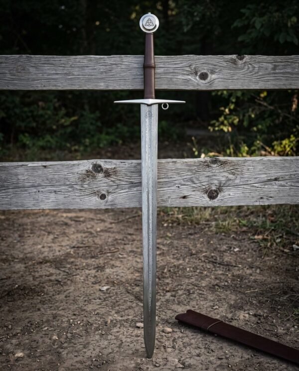 Folded Damascus arming sword blade with a shallow central fuller and an unsharpened display edge