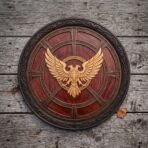 Front view of a red brown carved round shield with a pale double headed eagle and six spoke relief frame on weathered planks