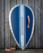 Front view of a teardrop Norman kite shield with blue panels and riveted steel rim, leather guige strap on the ground