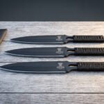 Hand forged 1095 steel Viking throwing knife set of three with cord wrapped handles laid on a wooden table by the roll