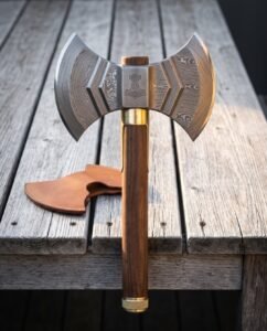 Hand forged Damascus double headed axe with layered twin crescent bits, an engraved Mjolnir cheek, walnut haft and brass collar standing on a weathered wooden deck