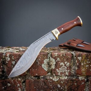 Hand forged Damascus kukri knife with brass bolster and rosewood handle, side view on a lichen covered brick wall with sheath