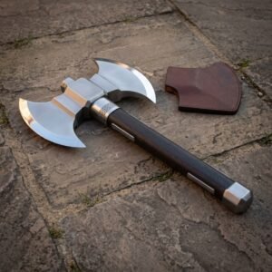 Hand forged double headed battle axe with polished twin crescent bits, engraved knotwork collar and dark hardwood haft on flagstones beside a leather edge cover