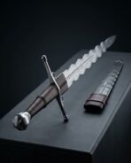 Hand forged flame bladed longsword with rune etched ricasso resting on a dark plinth beside the matching dagger in its sheath
