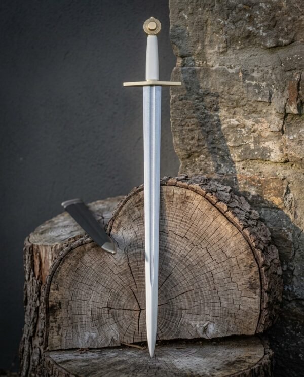 Hand forged medieval arming sword with polished tapering blade, brass wheel pommel and straight crossguard standing upright against a cut log and stone wall