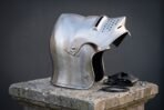Hand forged steel sallet helmet in polished 16 gauge mild steel with a raised hinged visor, long swept tail and a chased Vegvisir compass on a stone plinth