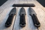 Hand forged throwing knives with cord wrapped handles, three knives from above pointing up on weathered boards below the roll