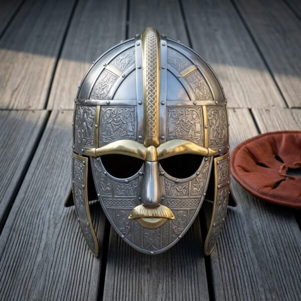 Hand forged viking helmet in the Sutton Hoo pattern, 18 gauge steel face mask with brass eyebrows, nose and moustache and embossed panels, on weathered grey decking
