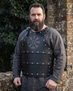 Hand made black leather Viking cuirass with Vegvisir engraved chest plate and steel studs worn by a bearded man outdoors
