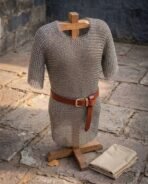 Hand made mild steel chainmail hauberk of butted round rings with short sleeves, shown on a wooden stand with a leather belt