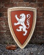 Hand painted wooden heater shield with a white rampant lion on a rust field and knotwork border, leaning on a red brick wall above a leather arm strap