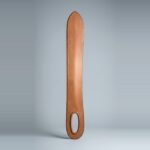 Leather dussack cut from one slab of vegetable tanned hide with an oval hand hole, rolled rim and twin brown stitch lines lying on a plain grey studio backdrop