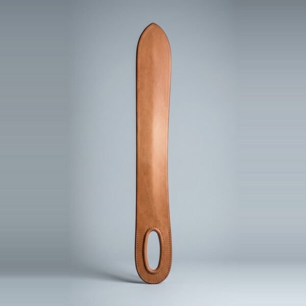 Leather dussack cut from one slab of vegetable tanned hide with an oval hand hole, rolled rim and twin brown stitch lines lying on a plain grey studio backdrop