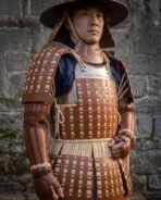 Leather lamellar samurai armour in close up on the wearer, showing the steel chest plate, laced scales and shoulder guards