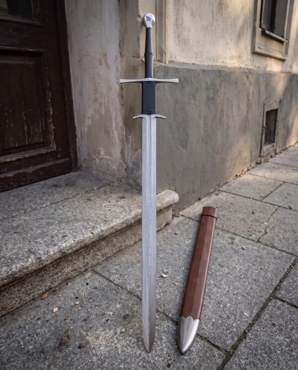 Long Damascus blade under a straight crossguard and a second down swept guard, black leather grip