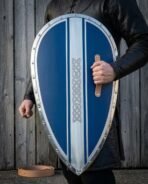 Man holding a blue Norman kite shield by its leather grip, riveted steel rim and knotwork band facing the camera