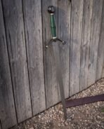 Norse Damascus sword with a dark brown leather scabbard and scrolled leaf quillons