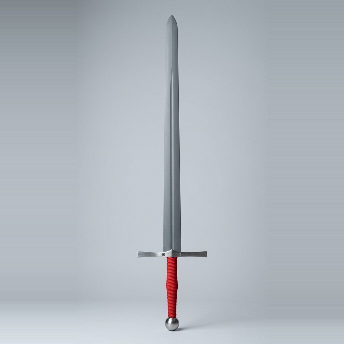 Tevrand nylon longsword waster Nylon longsword waster with a matte moulded blade, steel cross bolted through with two visible bolt heads, red cord grip and polished ball pommel against a plain grey studio backdrop