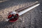Pierced shell guard with red backing panels, a side ring and a steel knuckle bow