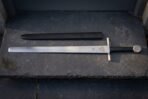 Plain square bar guard above a satin finished thirty inch double edged blade
