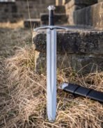 Polished steel longsword with a scalloped pommel and curved scrolled crossguard shown from the front in winter grass with its black scabbard resting alongside